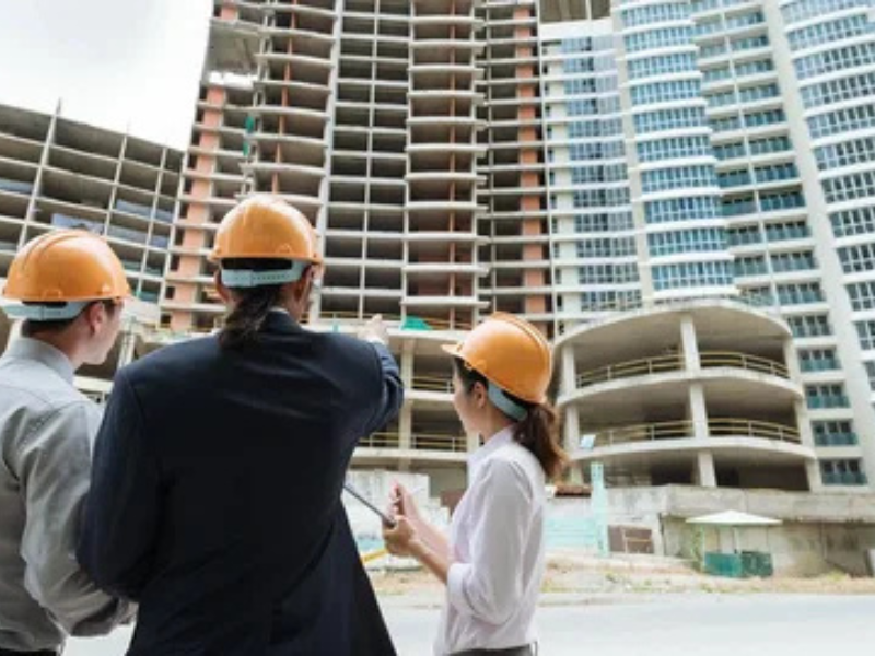 Engineers inspecting high-rise construction site for ALM Estimating’s commercial estimating services