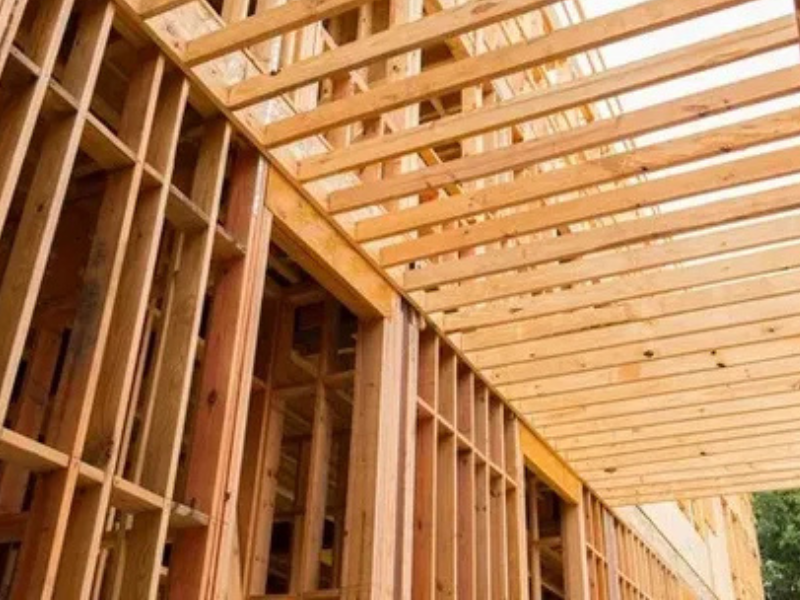 Wood framing structure of a building under construction, representing ALM Estimating’s lumber takeoff services.